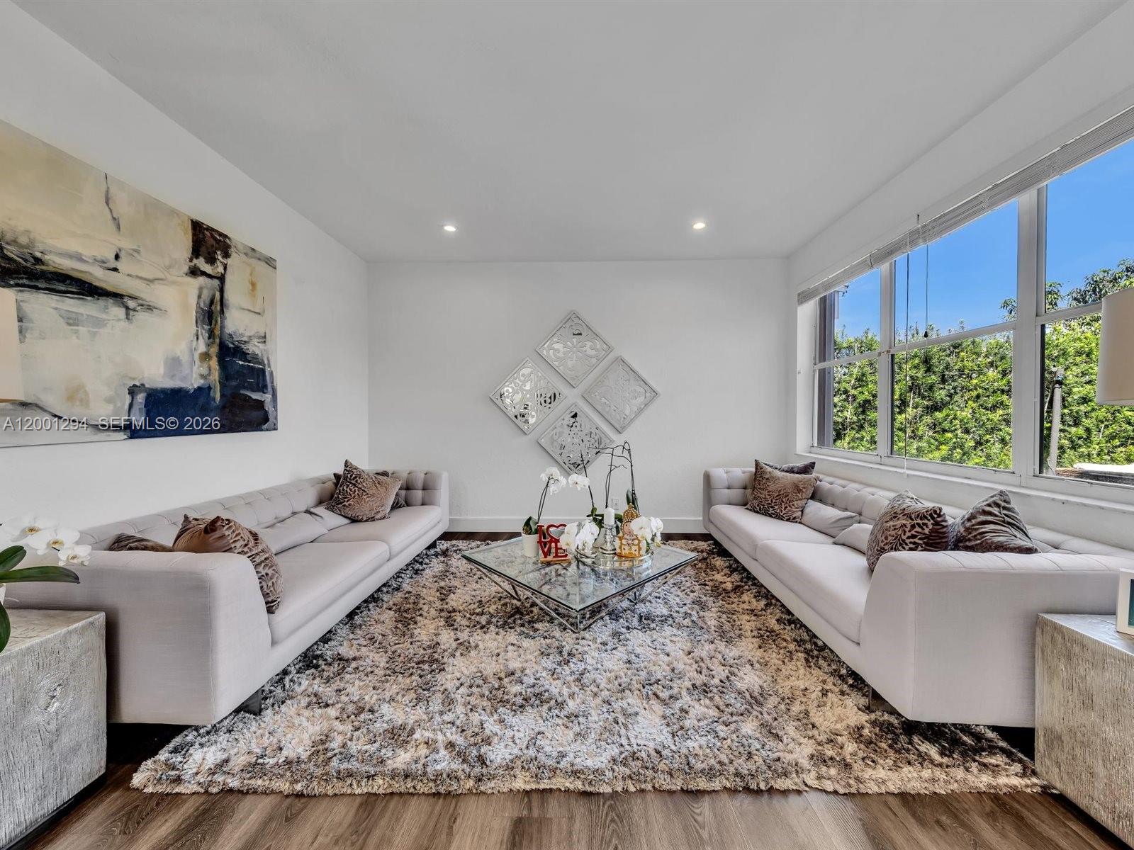 A living room features two grey sofas, a glass coffee table, and a shaggy rug — 1042 Thistle Creek Ct, Weston FL 33327, WESTON, FL