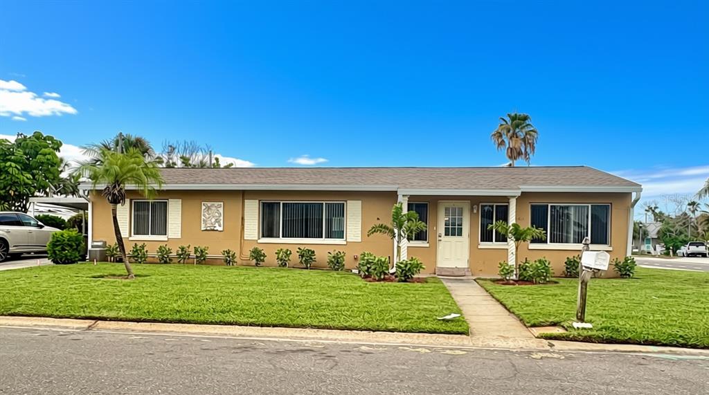 A single-story tan house with a gray shingled roof and a front lawn — 360 72ND AVENUE, ST PETERSBURG, FL