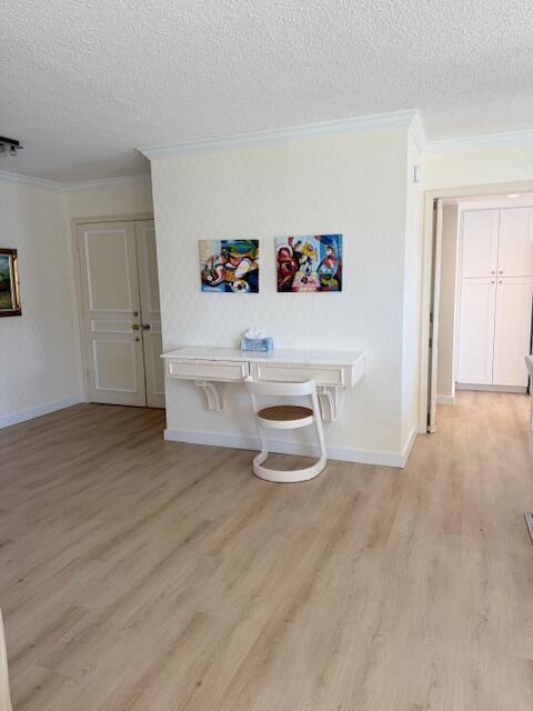 A wall-mounted white desk with a matching chair sits between two doors in a room — 1180 S Ocean Boulevard # D, Boca Raton FL 33432, BOCA RATON, FL