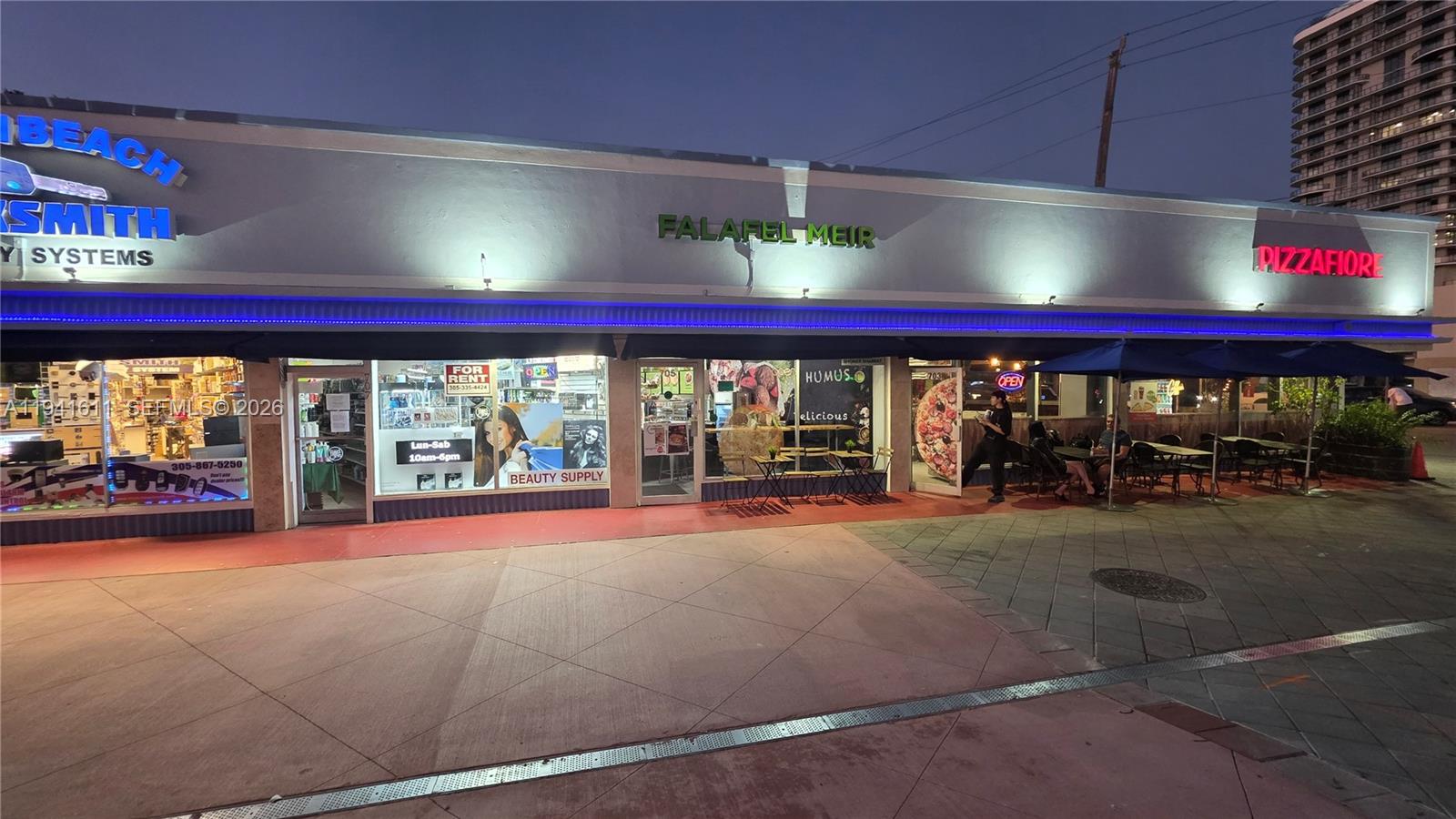A street-level view shows a row of storefronts including a locksmith, a falafel restaurant, and a pizzeria — 707 71st St, Miami Beach FL 33141, MIAMI BEACH, FL