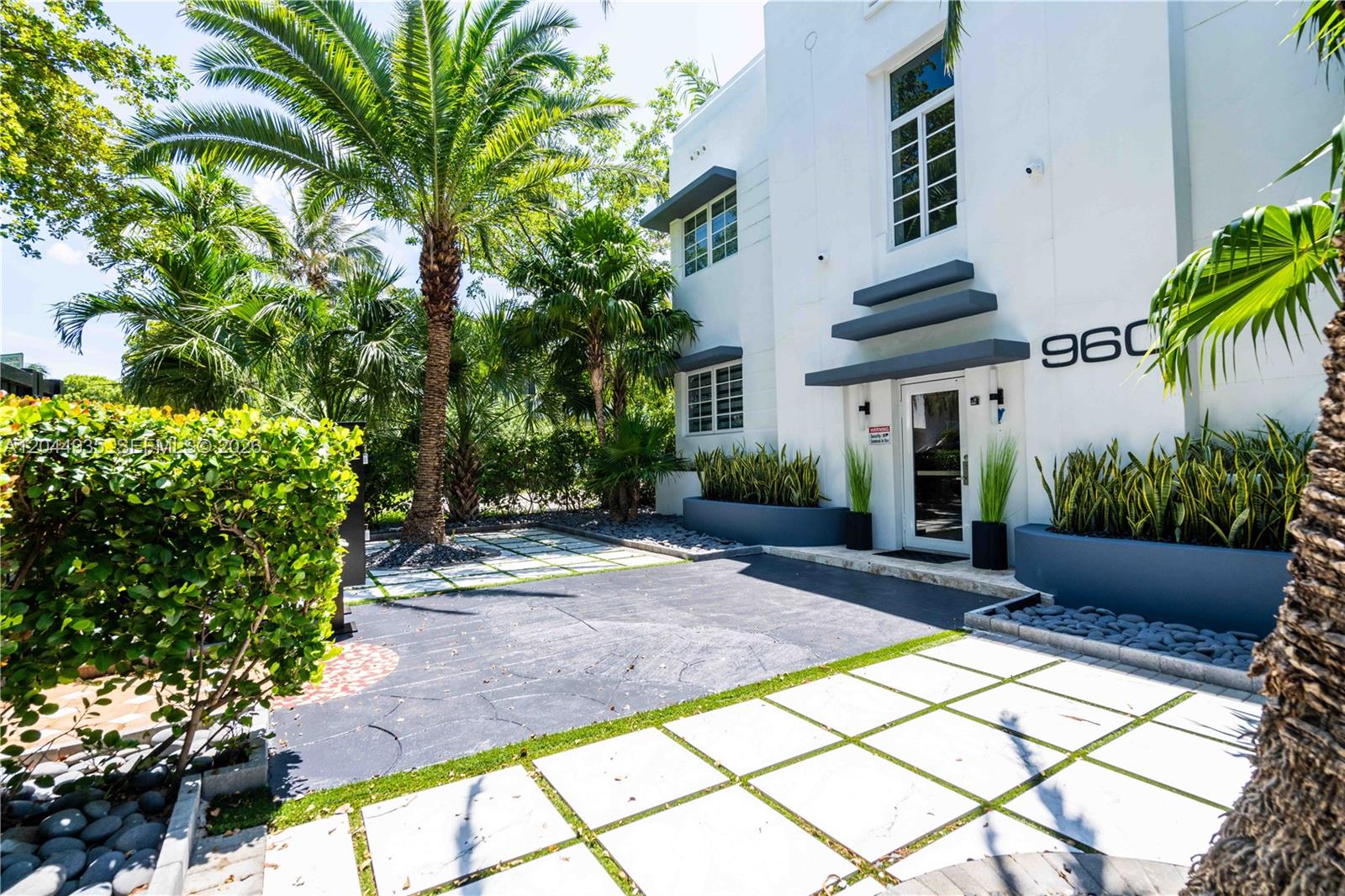 A white two-story building with a glass entrance, palm trees, and a paved front courtyard — 960 Jefferson Ave, Miami Beach FL 33139, MIAMI BEACH, FL