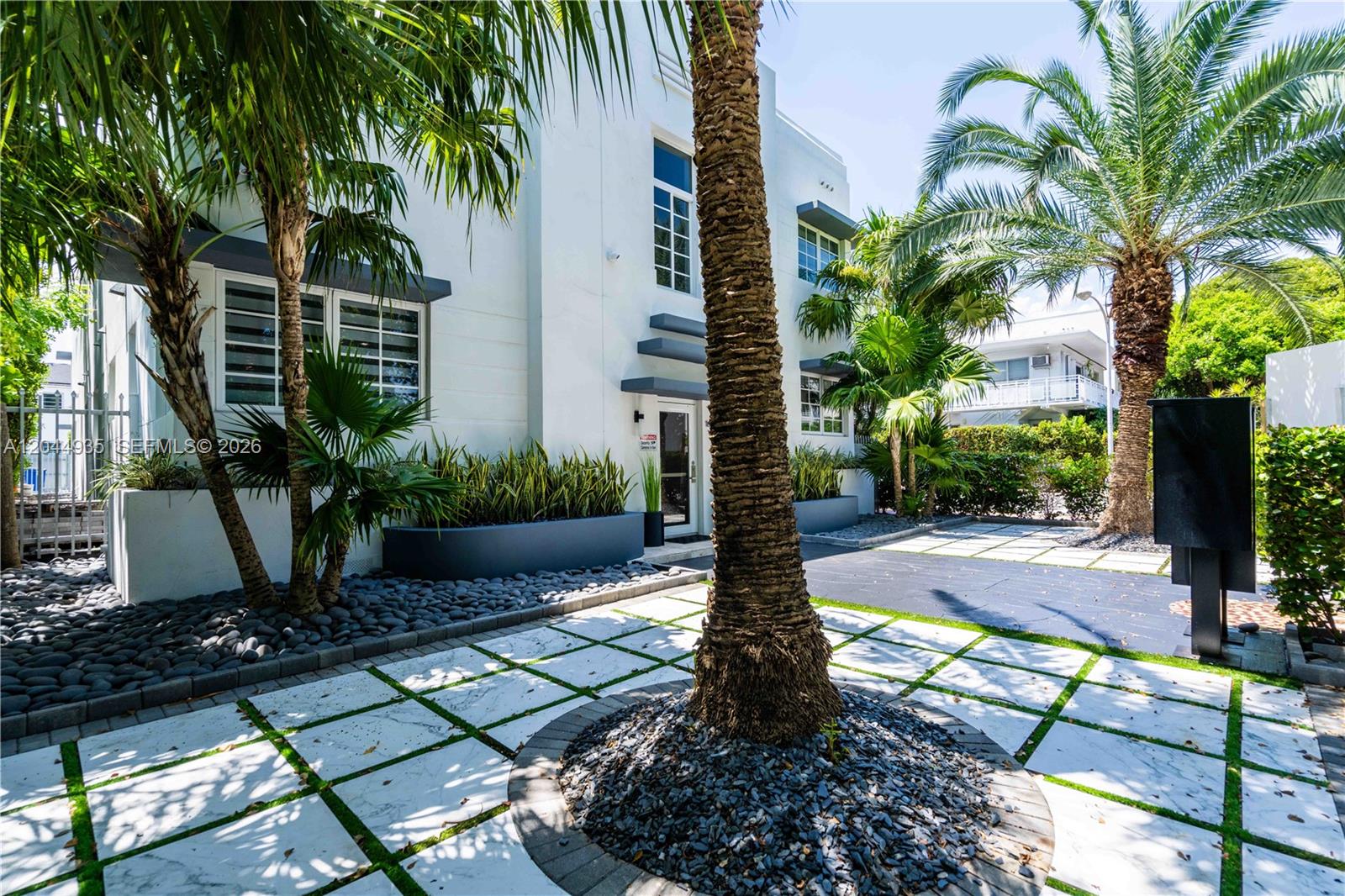 A white multi-story building features a paved courtyard with a central palm tree — 960 Jefferson Ave, Miami Beach FL 33139, MIAMI BEACH, FL