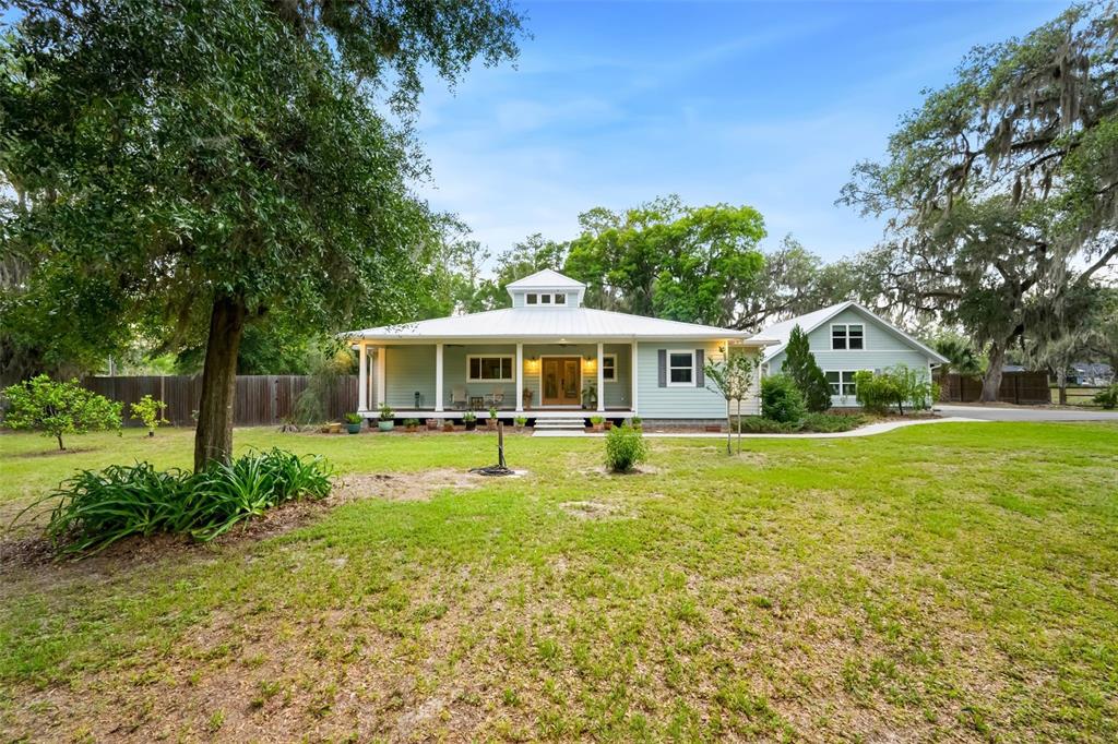 A light green house with a metal roof and a cupola sits on a lawn — 2604 NW 31ST AVENUE, GAINESVILLE, FL