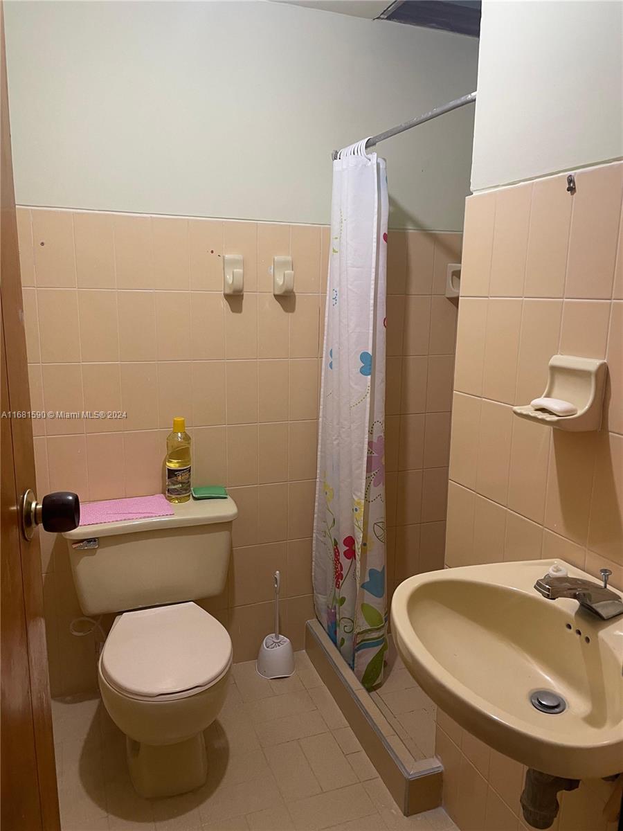 This bathroom features peach-colored wall tiles, a pedestal sink, a toilet, and a shower stall — Carrera 22 # 3 02 Buga Los Portales del Rios, FL, FL