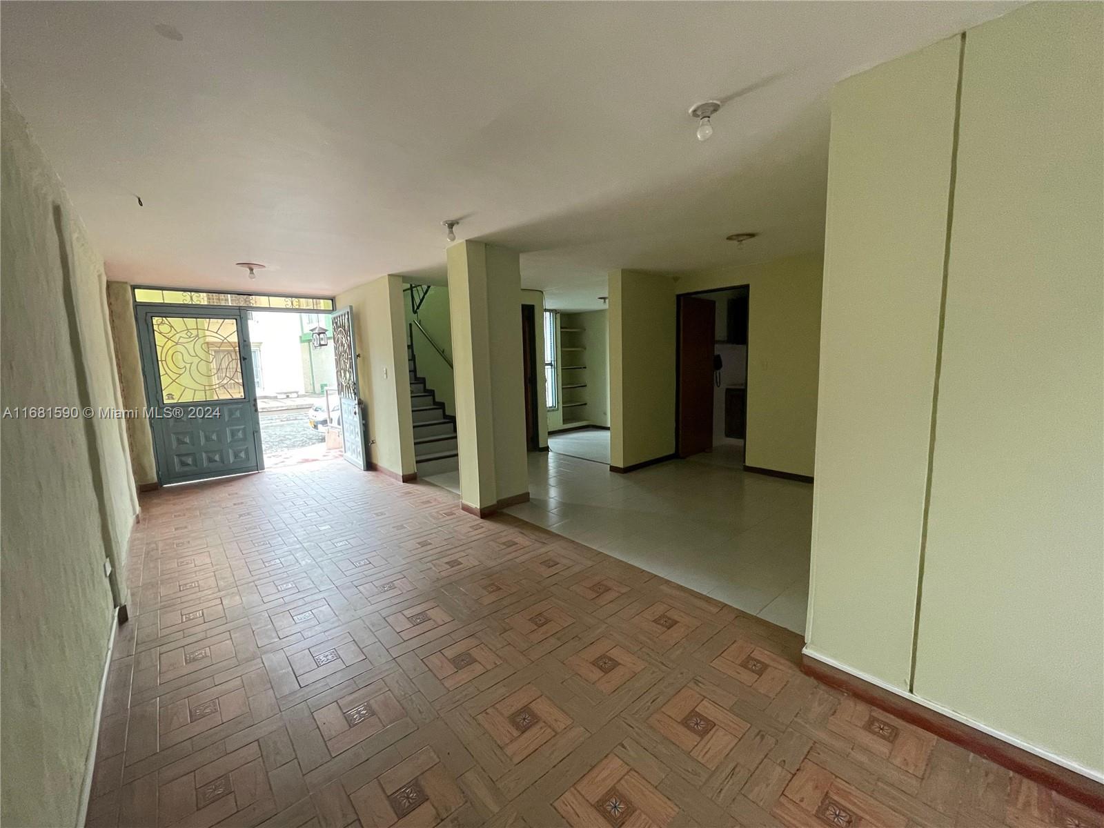 An open-concept interior space features tiled flooring, a staircase, and a decorative front door — Carrera 22 # 3 02 Buga Los Portales del Rios, FL, FL
