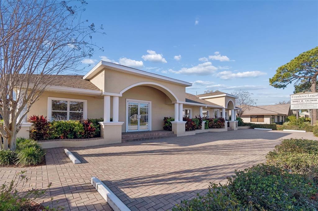 A beige commercial building with a paved parking lot and a prominent arched entryway — 5308 CENTRAL AVENUE, ST PETERSBURG, FL