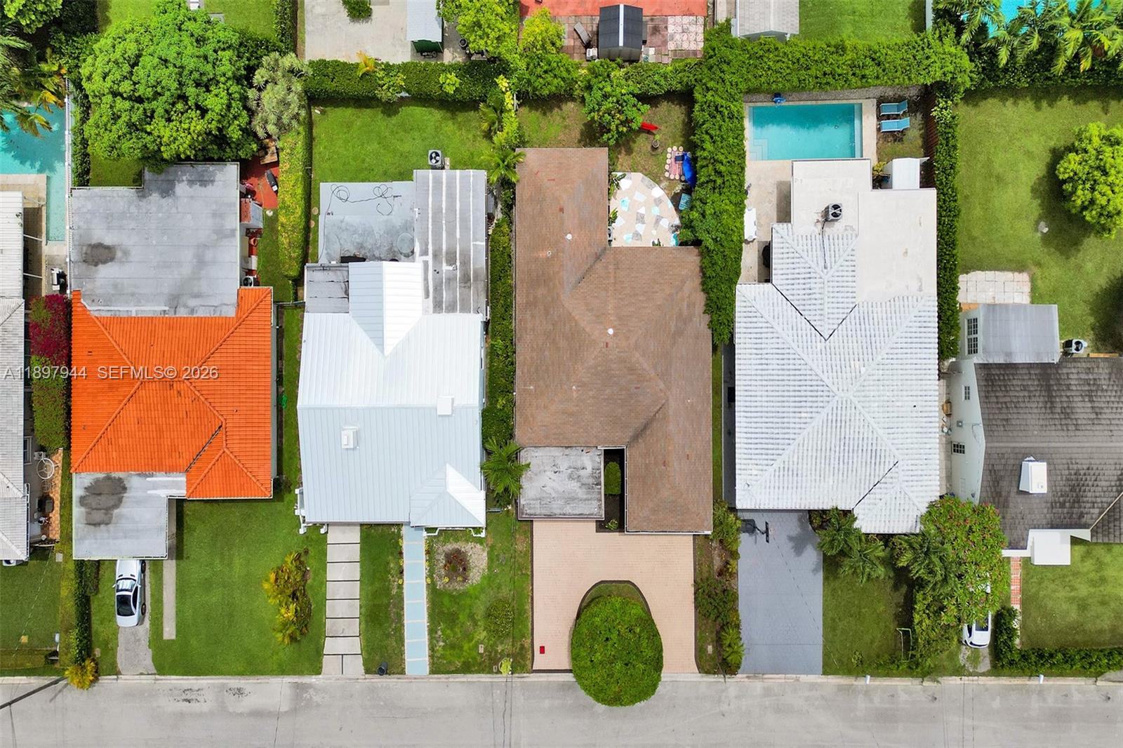An aerial view shows four residential houses with various roof styles, driveways, and backyard pools — 8851 Byron Ave, Surfside FL 33154, SURFSIDE, FL
