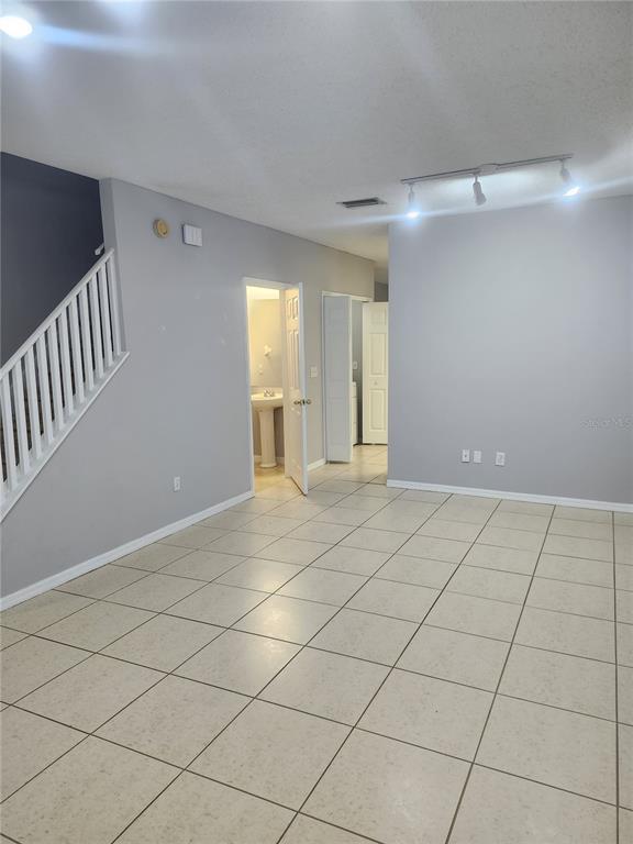 A tiled living area features a staircase, a half bathroom, and track lighting — 6512 OSPREY LAKE CIRCLE, RIVERVIEW, FL