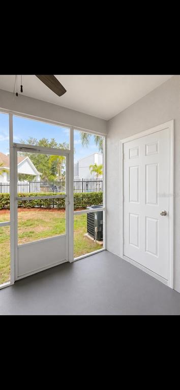 A screened-in porch with gray flooring, a white door, and a view of the yard — 6512 OSPREY LAKE CIRCLE, RIVERVIEW, FL