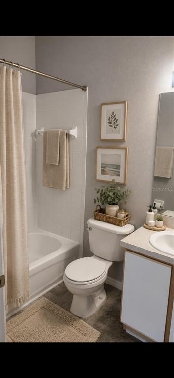A bathroom features a white toilet, a bathtub with a shower curtain, and a vanity — 6512 OSPREY LAKE CIRCLE, RIVERVIEW, FL
