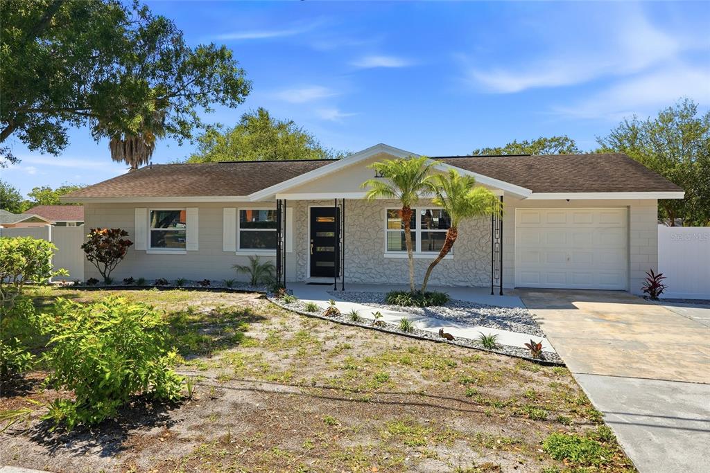 A single-story house with a beige exterior, stone facade, and a one-car garage — 1966 119TH STREET, LARGO, FL