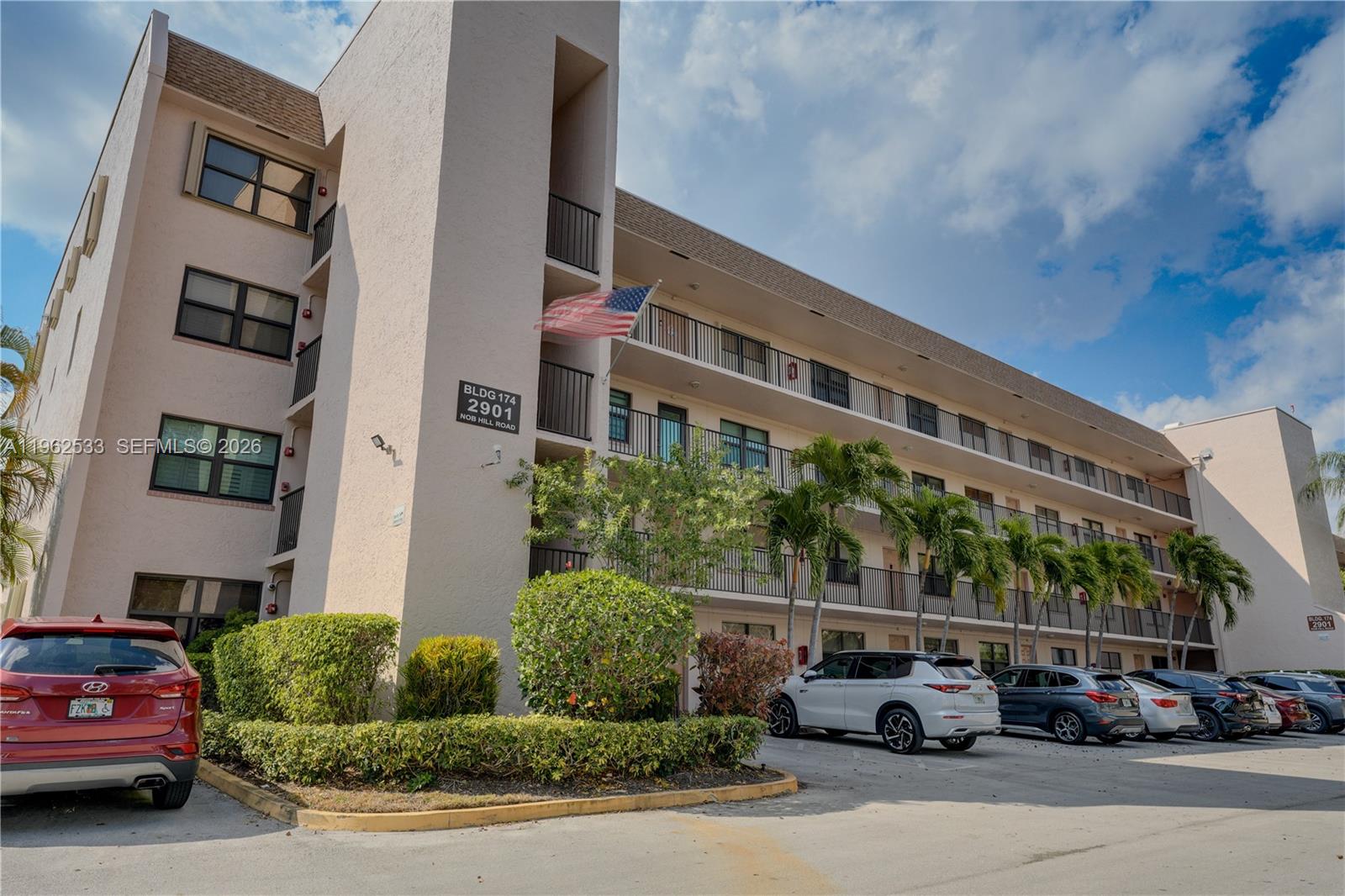 A multi-story apartment building with a parking lot and palm trees in front — 2901 N Nob Hill Rd # 303, Sunrise FL 33322, SUNRISE, FL
