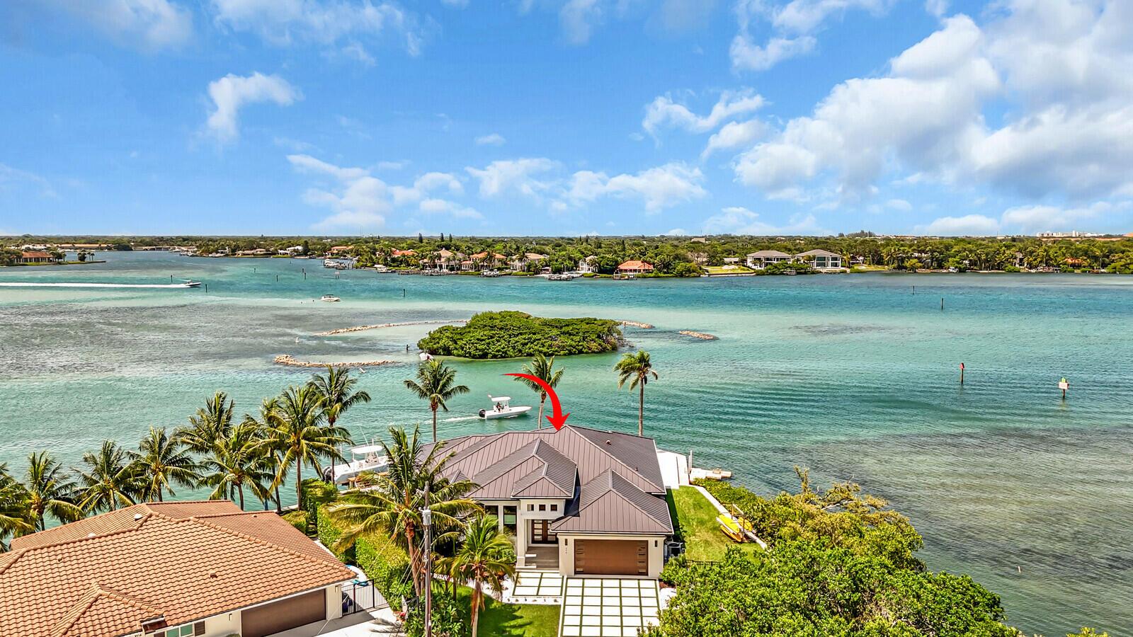 An aerial view shows a waterfront house with a dark metal roof and palm trees — 974 Marlin Drive, Jupiter FL 33458, JUPITER, FL