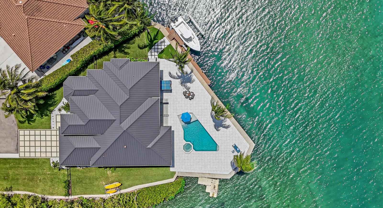 An aerial view shows a waterfront house with a pool, patio, and private boat dock — 974 Marlin Drive, Jupiter FL 33458, JUPITER, FL