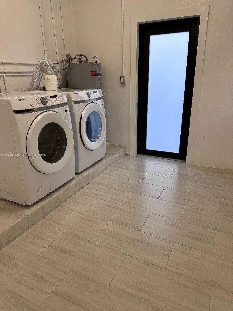 A laundry room features a Samsung washer and dryer, tile flooring, and a glass door — 2750 Washington St # 0, Hollywood FL 33020, HOLLYWOOD, FL