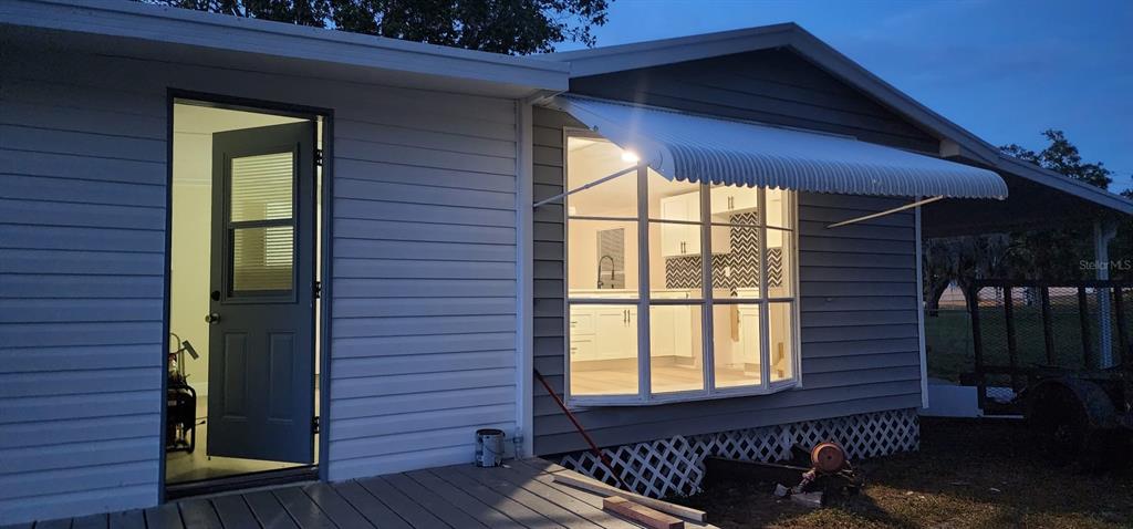 A small, empty bedroom features light-colored wood-look flooring, beige walls, and a single window — 14810 THOMPSON AVENUE, HUDSON, FL