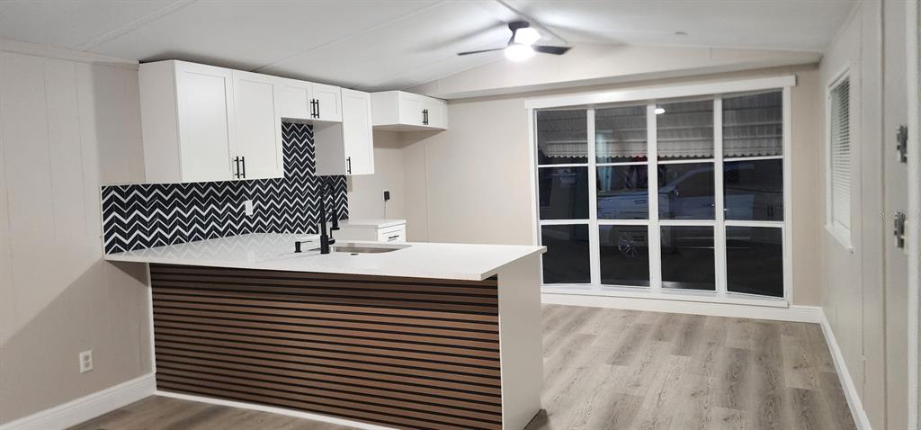 The exterior of a light gray mobile home features white lattice skirting and metal awnings — 14810 THOMPSON AVENUE, HUDSON, FL