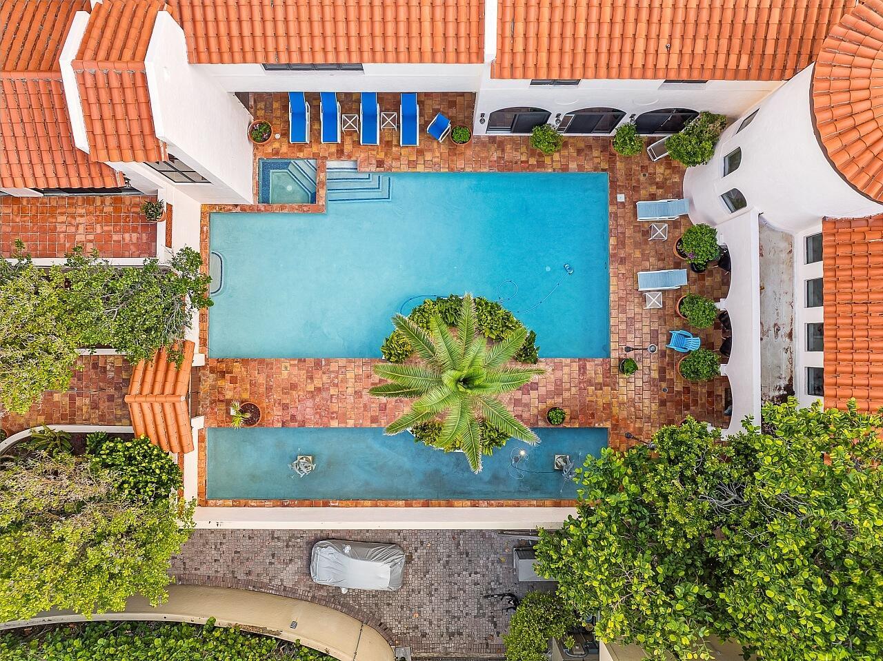 An aerial view shows a swimming pool with a central palm tree and surrounding patio — 1 Ocean Lane, Manalapan FL 33462, MANALAPAN, FL