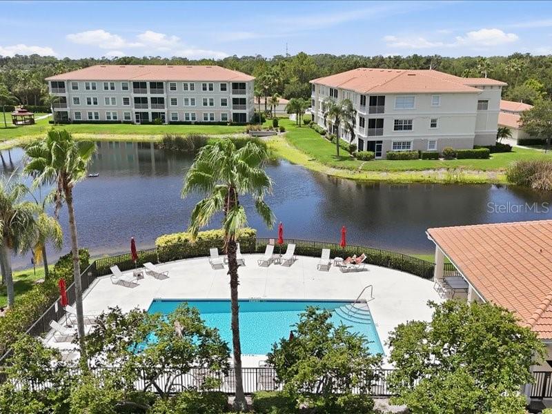 An aerial view shows a swimming pool and patio area situated between two apartment buildings — 600 SAN LINO CIRCLE UNIT 624, VENICE, FL