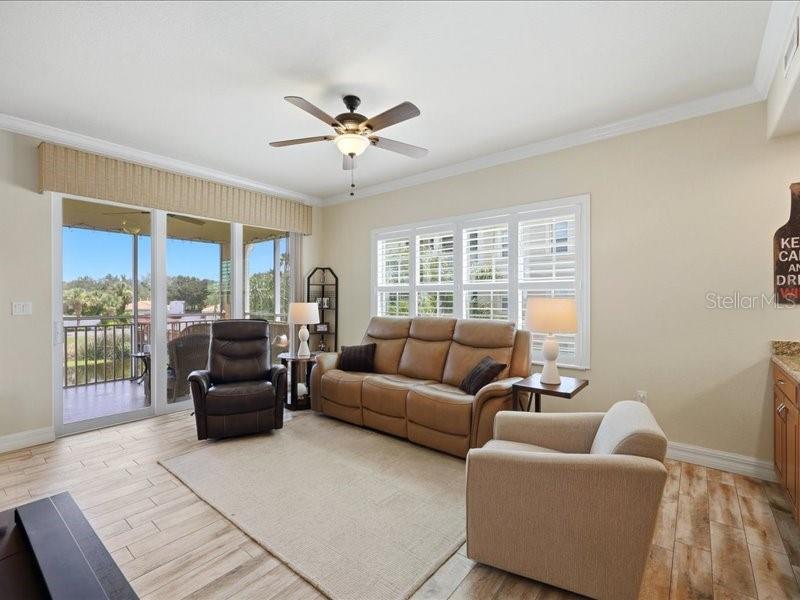 A living room features a tan sofa, a leather recliner, and a sliding glass door — 600 SAN LINO CIRCLE UNIT 624, VENICE, FL