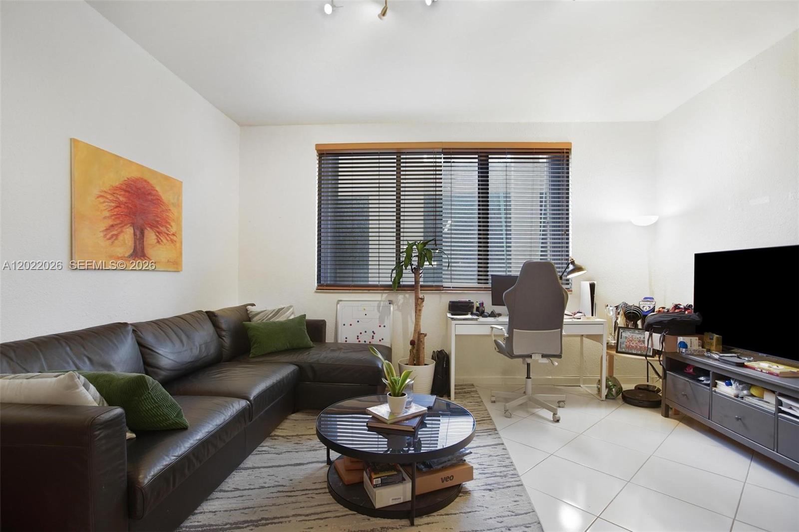 A living room features a dark leather sectional, a glass coffee table, and a desk — 540 Brickell Key Dr # 308, Miami FL 33131, MIAMI, FL
