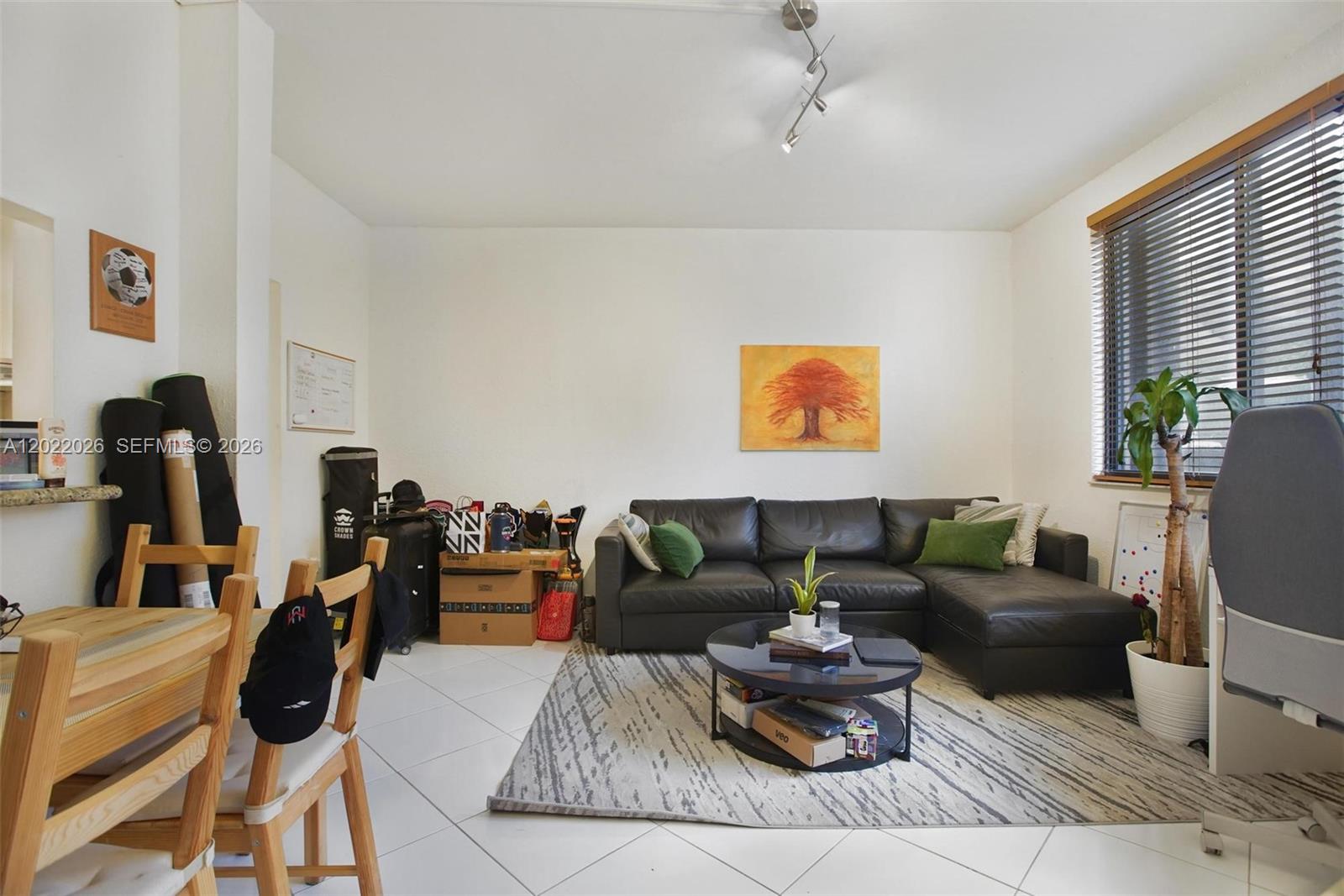 A living room features a black sectional sofa, a round coffee table, and a dining area — 540 Brickell Key Dr # 308, Miami FL 33131, MIAMI, FL