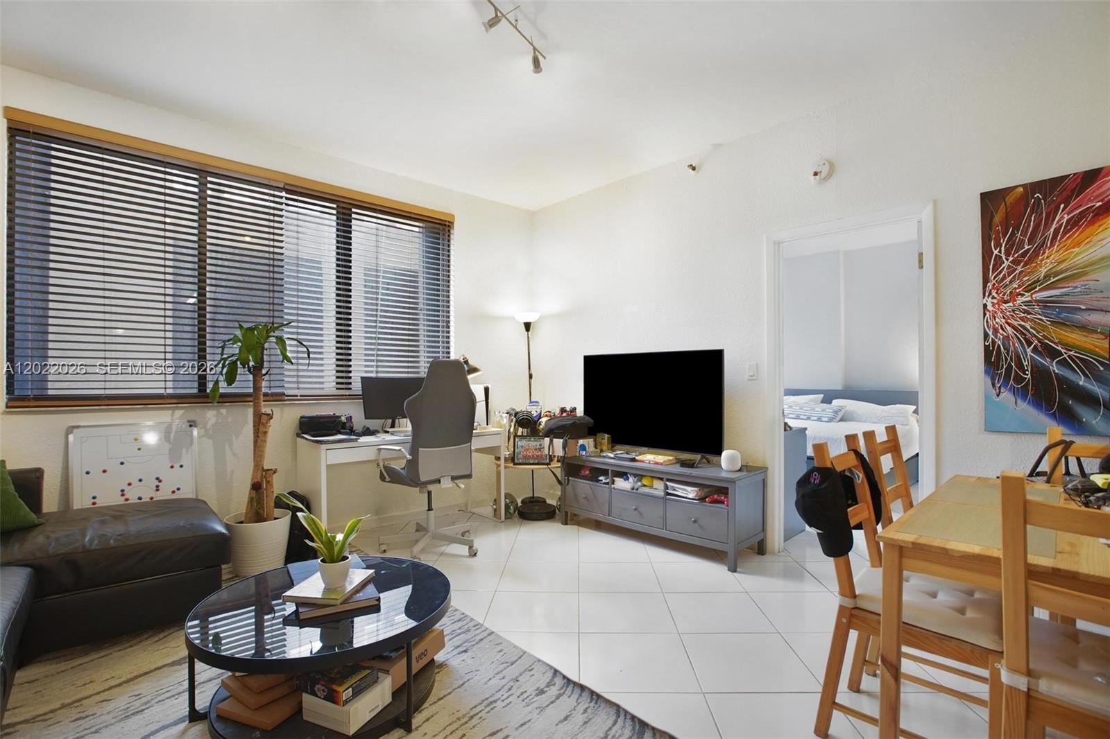 A living room features white tile floors, a desk, a television console, and a dining area — 540 Brickell Key Dr # 308, Miami FL 33131, MIAMI, FL