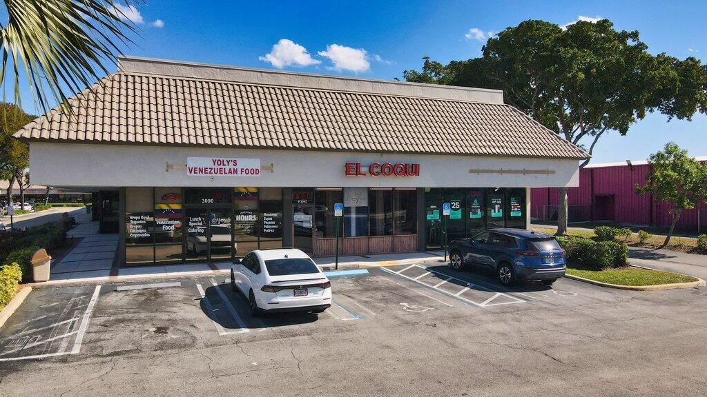An exterior view of a commercial building with two storefronts and a parking lot — 3092 S Jog Road, FL 33463, FL