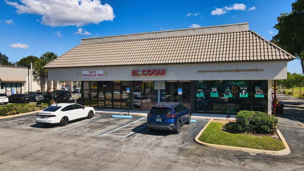 Exterior view of a commercial building with a tan tiled roof and parking lot — 3092 S Jog Road, FL 33463, FL