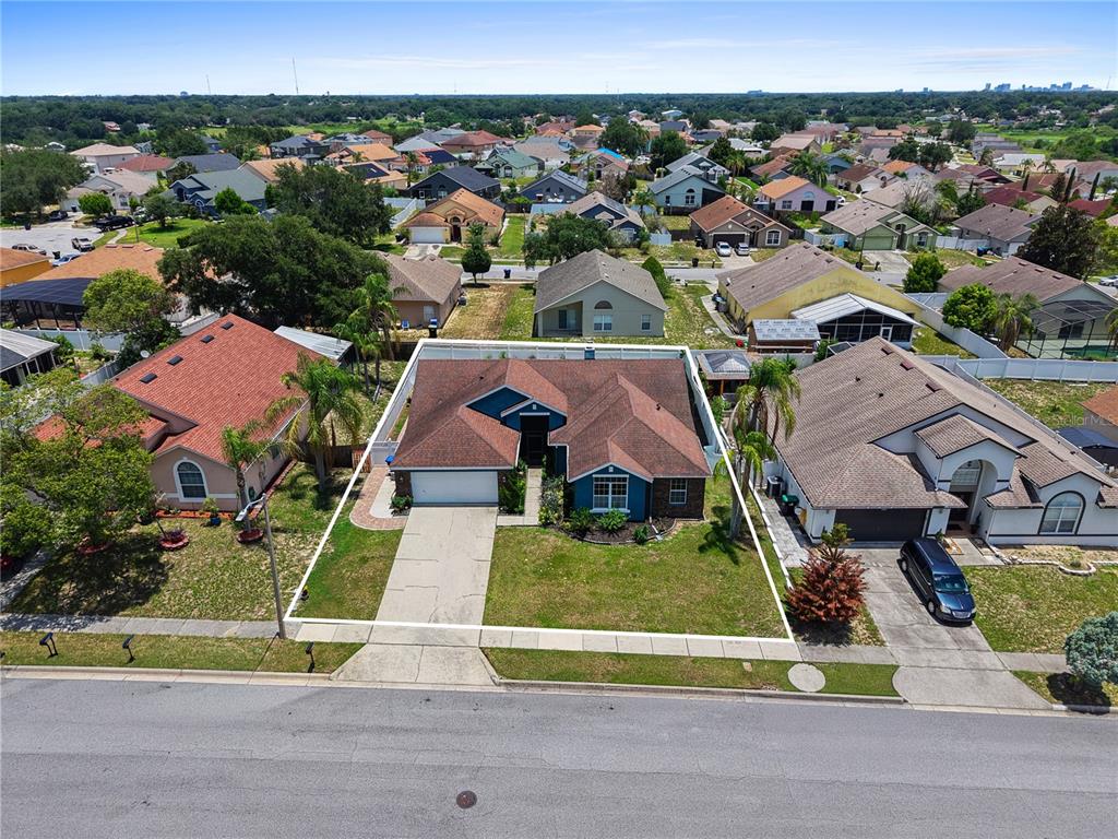 An aerial view shows a single-story suburban house with a brown roof and blue siding — 4441 BEAGLE STREET, ORLANDO, FL