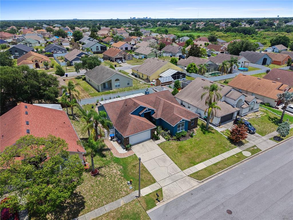 An aerial view shows a blue suburban house with a brown roof and concrete driveway — 4441 BEAGLE STREET, ORLANDO, FL