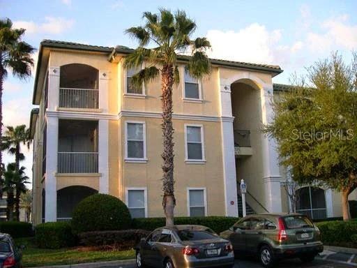 A three-story apartment building with beige stucco walls and a palm tree in front — 2740 MAITLAND CROSSING WAY UNIT 207, ORLANDO, FL