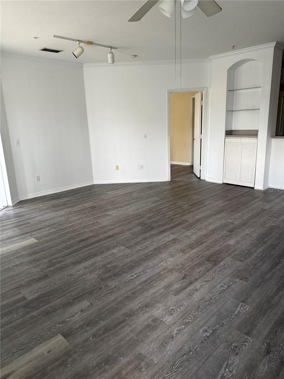 An empty room with gray wood-look flooring, white walls, a ceiling fan, and built-in shelving — 2740 MAITLAND CROSSING WAY UNIT 207, ORLANDO, FL