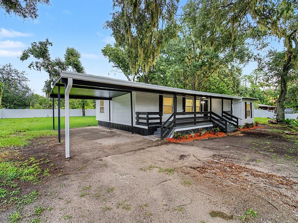 A single-story house with a carport, a front porch, and a white fence — 3817 WARD ROAD, LAKELAND, FL