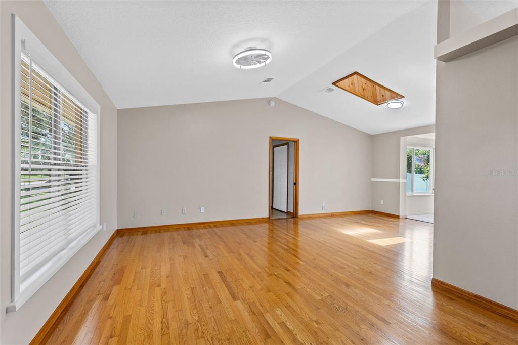 An empty room with hardwood floors, a vaulted ceiling, and a wooden skylight — 1369 WOOD LAKE CIRCLE, ST CLOUD, FL