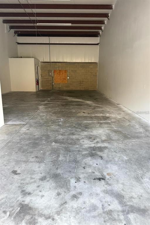 An empty industrial warehouse space features a concrete floor, exposed ceiling beams, and block walls — 4500 NE 35 STREET, OCALA, FL