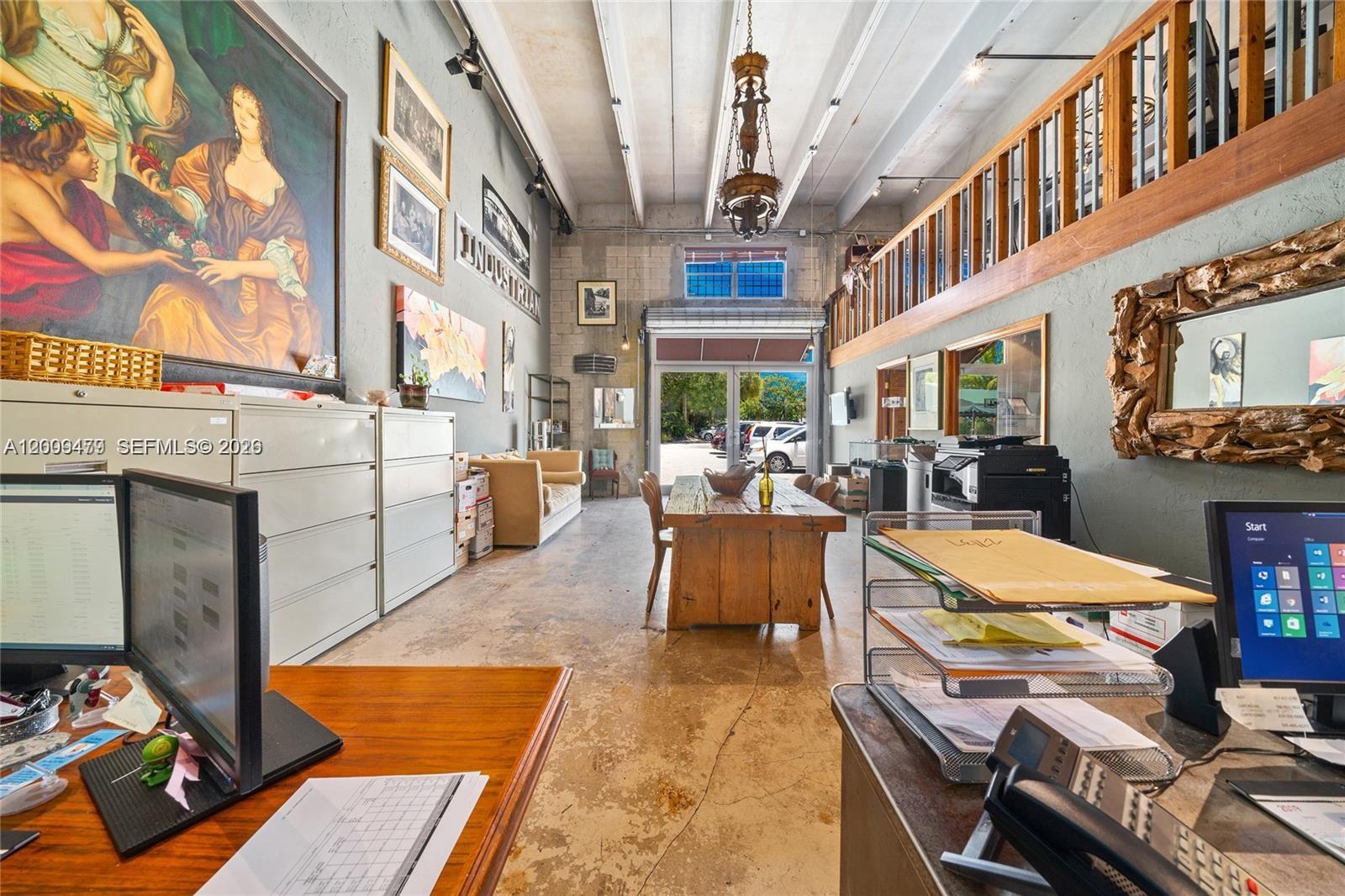 An open loft office features wood floors, exposed concrete block walls, and a metal railing — 5582 NE 4th Ct # 6A, Miami FL 33137, MIAMI, FL