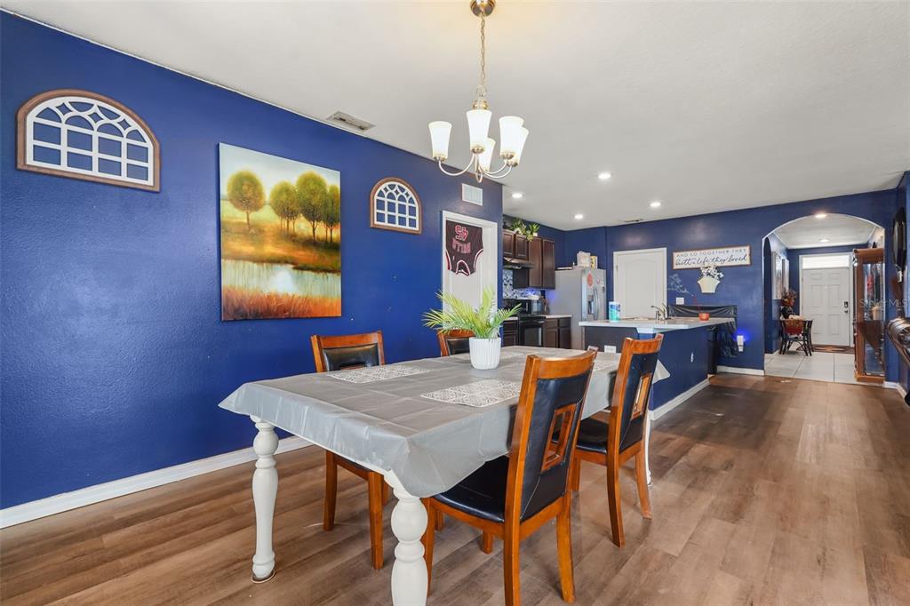 A dining room with blue walls, a rectangular table, and wood-look flooring — 931 SUMMER GLEN DRIVE, WINTER HAVEN, FL