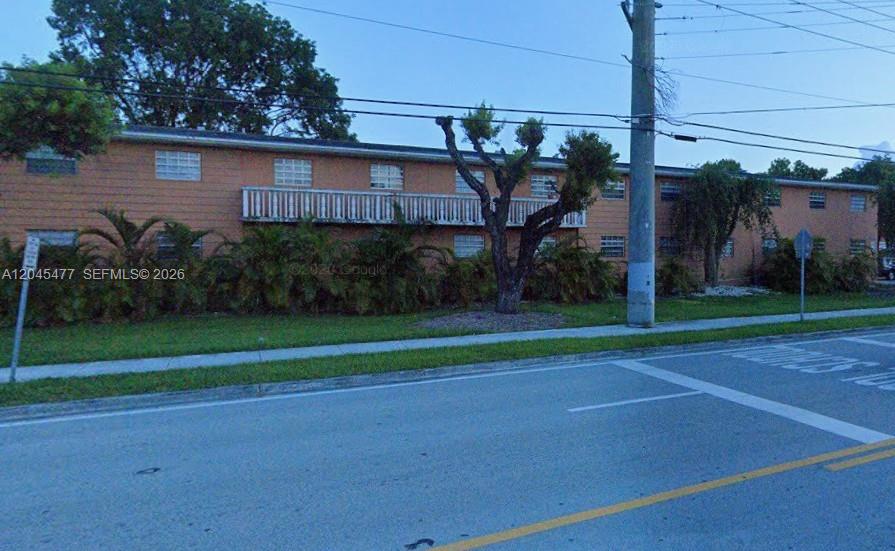A two-story, orange-colored apartment building stands behind a row of palm trees and landscaping — 9760 SW 184th St # 12D, Cutler Bay FL 33157, CUTLER BAY, FL
