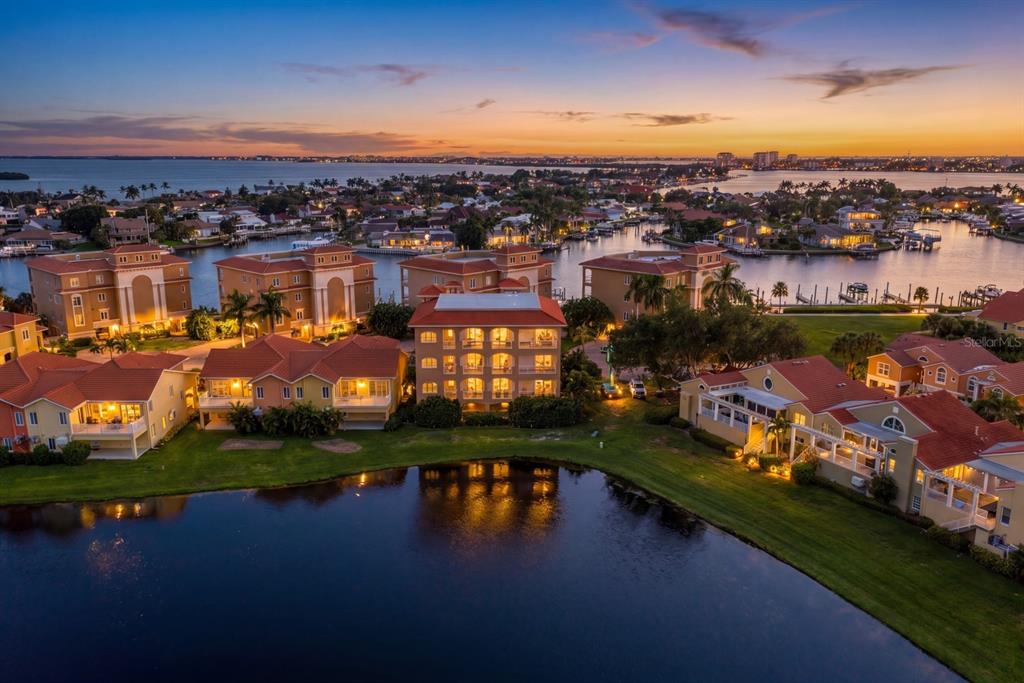 An aerial view of multi-story residential buildings with orange roofs situated beside a calm lake — 43 BAYVIEW COURT S UNIT A, ST PETERSBURG, FL