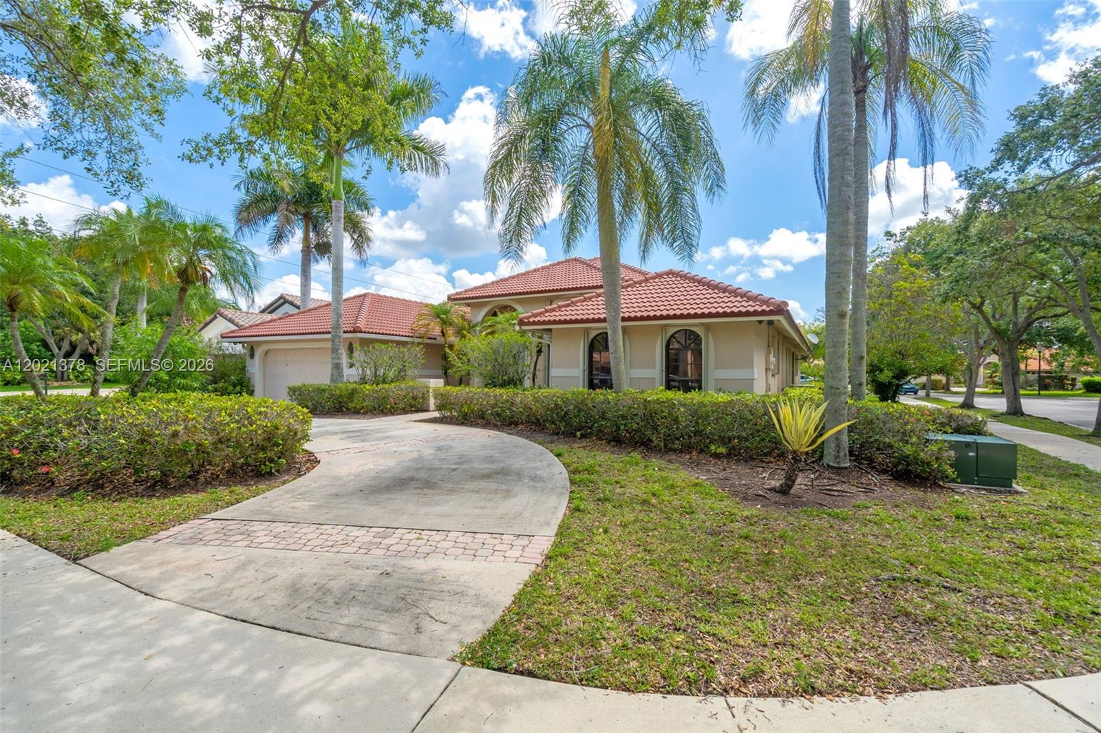 A single-story house with a red tile roof, arched windows, and a curved concrete driveway — 1051 Deerpath Ct, Weston FL 33326, WESTON, FL