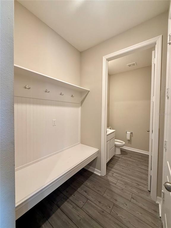 A mudroom with a built-in bench and coat hooks leads into a small bathroom — 11357 CAY SPRUCE WAY, SAN ANTONIO, FL