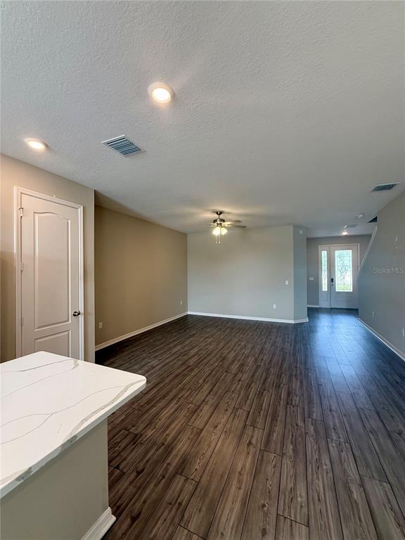 An open-concept living area features wood-look tile flooring, recessed lighting, and a kitchen island — 11357 CAY SPRUCE WAY, SAN ANTONIO, FL