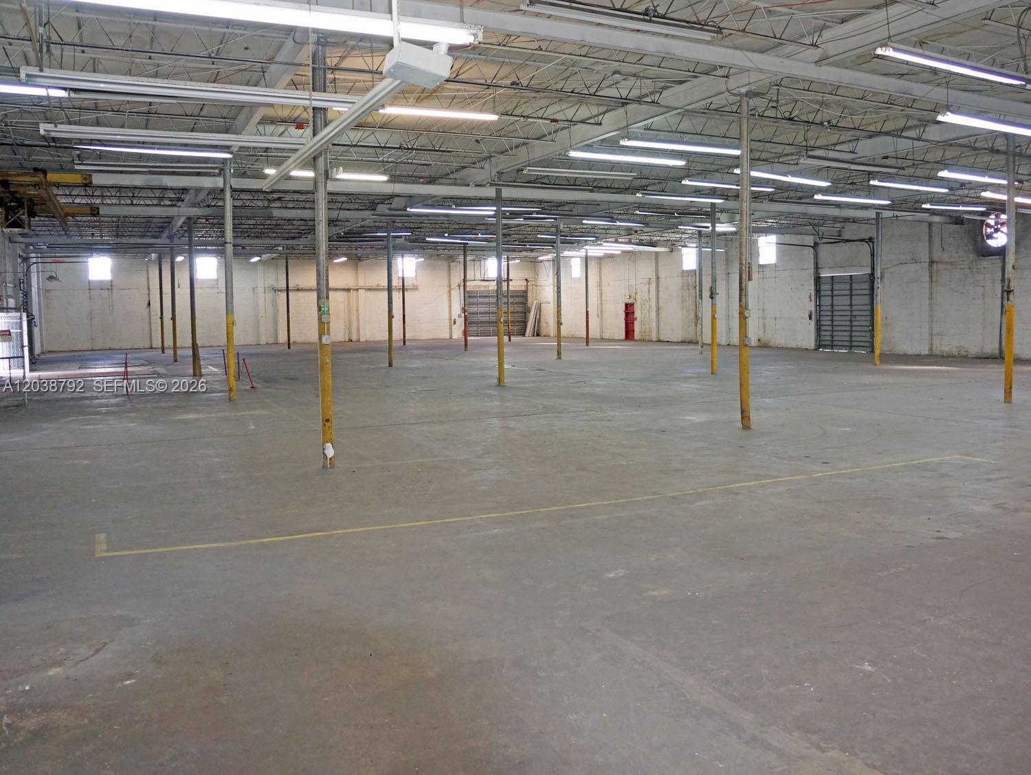 A large, open industrial warehouse space features concrete floors, exposed ceiling trusses, and support columns — 3690 NW 52nd St, Hialeah FL 33142, HIALEAH, FL