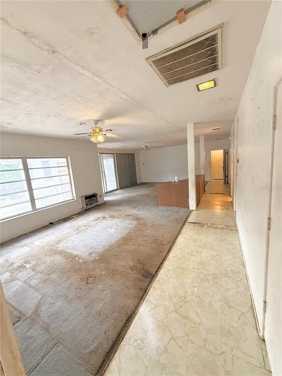 A living area features worn carpeting, a ceiling fan, and a tiled entryway — 400 LAKE MAGGIORE BOULEVARD S, ST PETERSBURG, FL