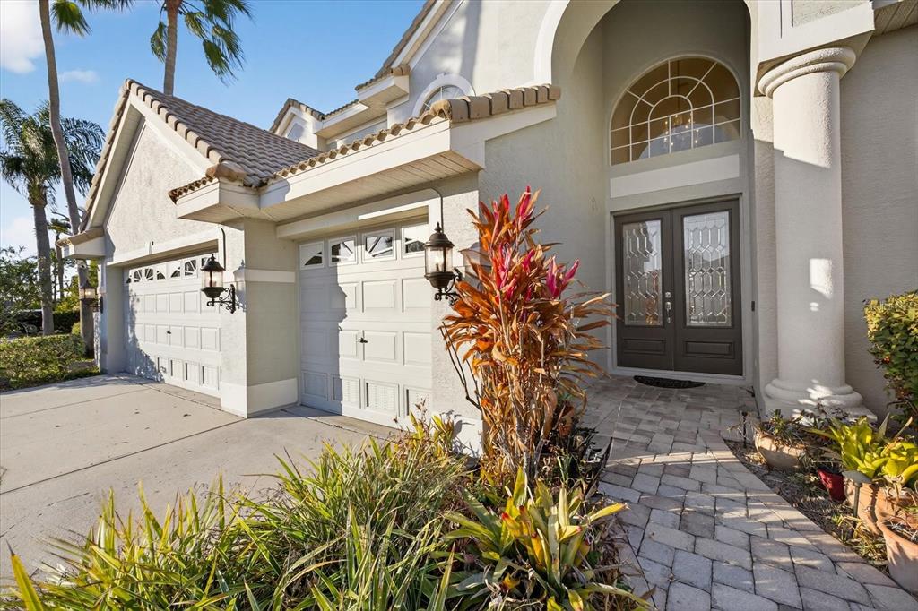 The exterior of a house features a paved walkway, double front doors, and a garage — 5510 E LONGBOAT BOULEVARD, TAMPA, FL