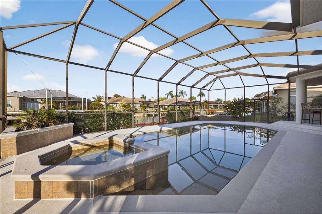 A screened-in pool and spa area with a view of a canal and neighboring homes — 5510 E LONGBOAT BOULEVARD, TAMPA, FL