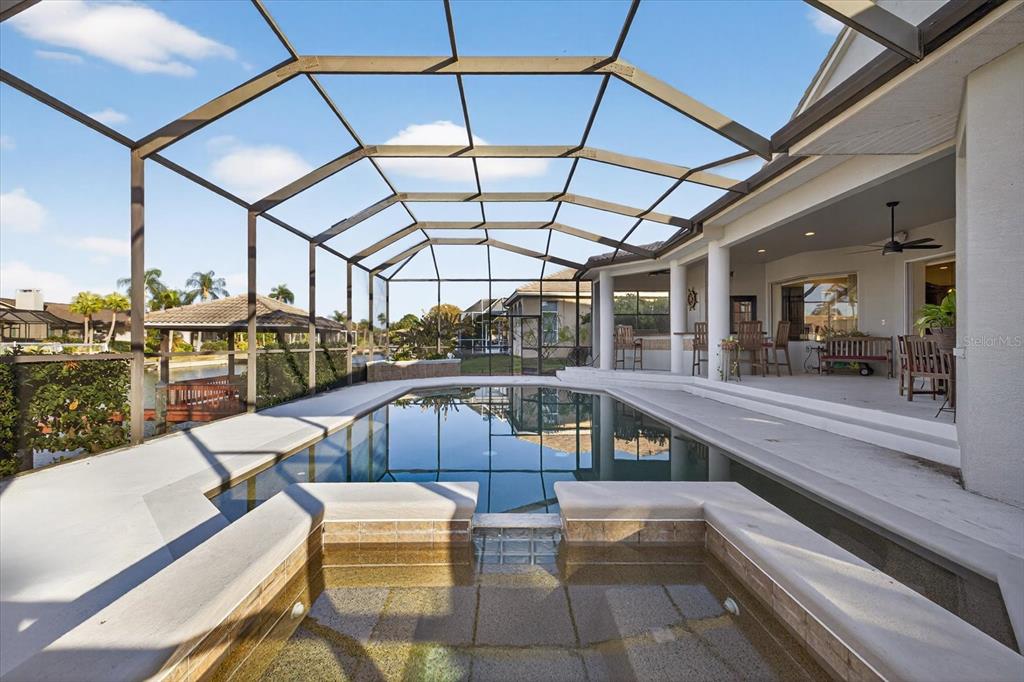 A screened-in pool and spa area with a covered patio overlooking a canal — 5510 E LONGBOAT BOULEVARD, TAMPA, FL