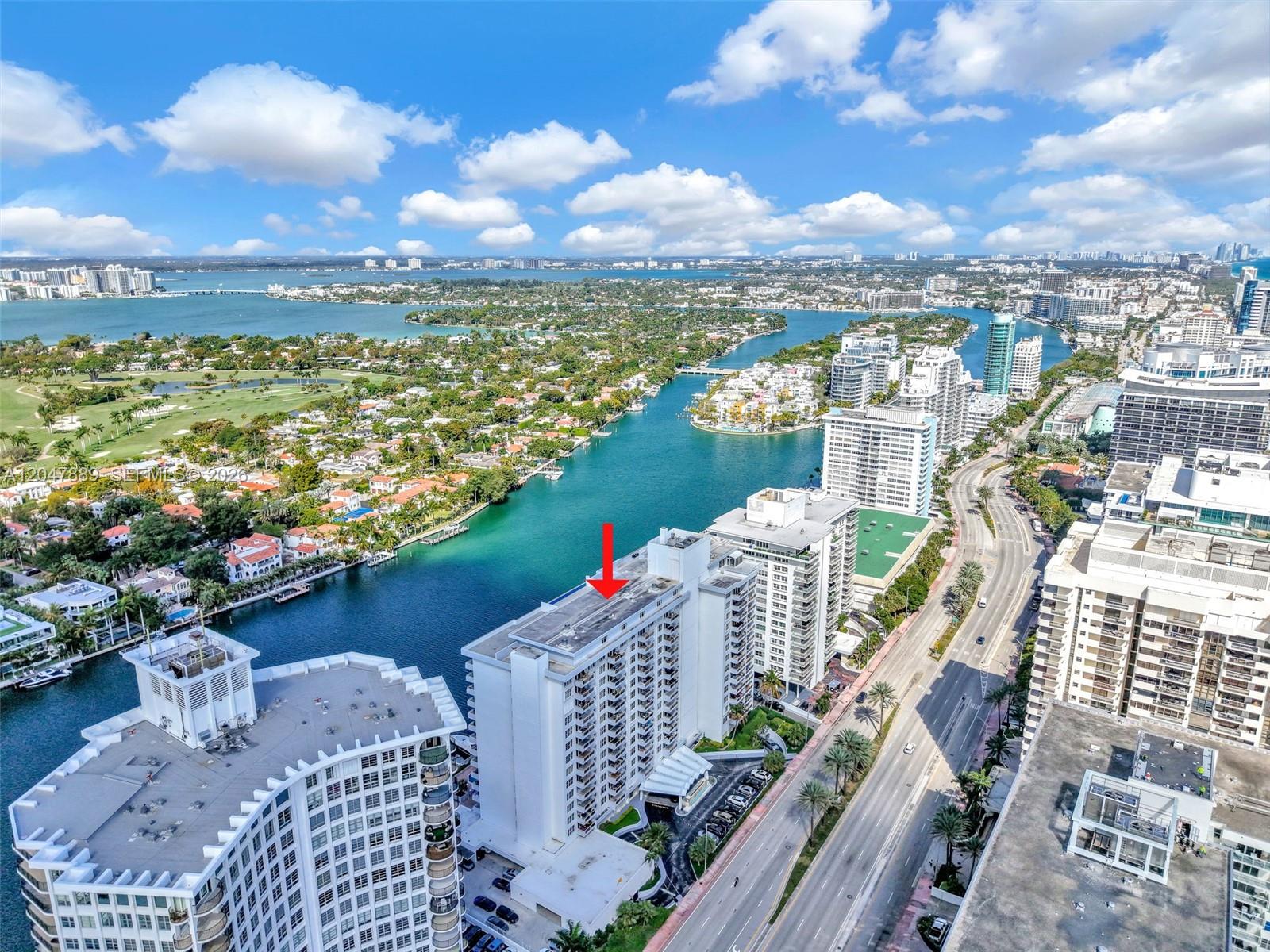 An aerial view shows a high-rise residential building with a red arrow pointing toward its roof — 5700 Collins Ave # 6J, Miami Beach FL 33140, MIAMI BEACH, FL