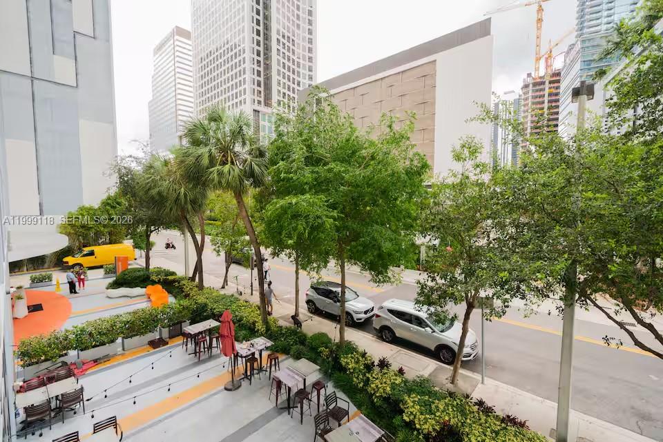 An elevated view shows an outdoor patio area with tables and seating overlooking a city street — 31 SE 6th St # 301, Miami FL 33131, MIAMI, FL